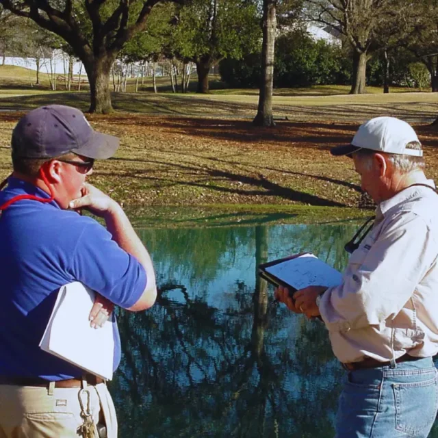 Owner Kenny Zwahr consulting with a client by their pond