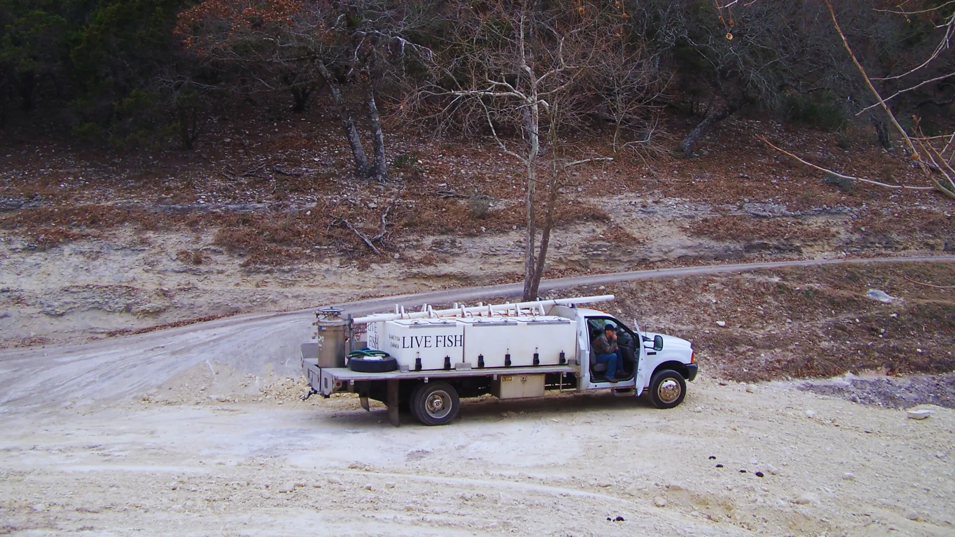 Delivery truck at a customer pond in the Texas Hill Country