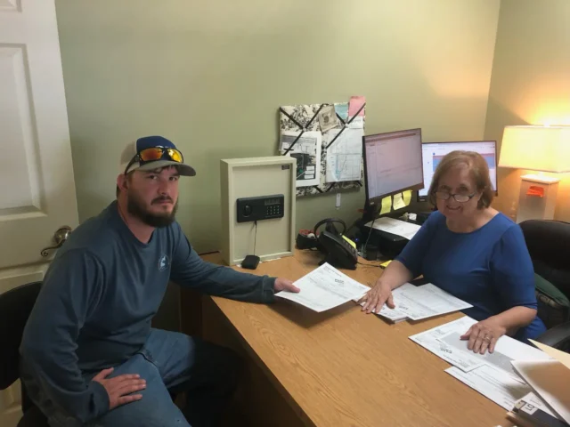 Office Manager Kay Roy with a customer at a Slab Sale