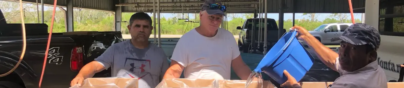 Workers and a customer at a Slab Sale event, putting fish in Live-Pak boxes